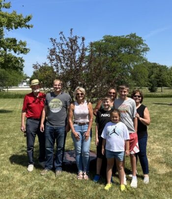 Legacy tree planted with spring grove nursery. Several people standing in front of a tree.